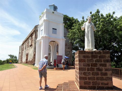 Saint Francis Xavier statue in front of St. Paul’s Church and the white lighthouse added much later by the British.
