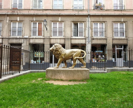 The golden lion statue, symbol of the city, at Place de la Basoche.