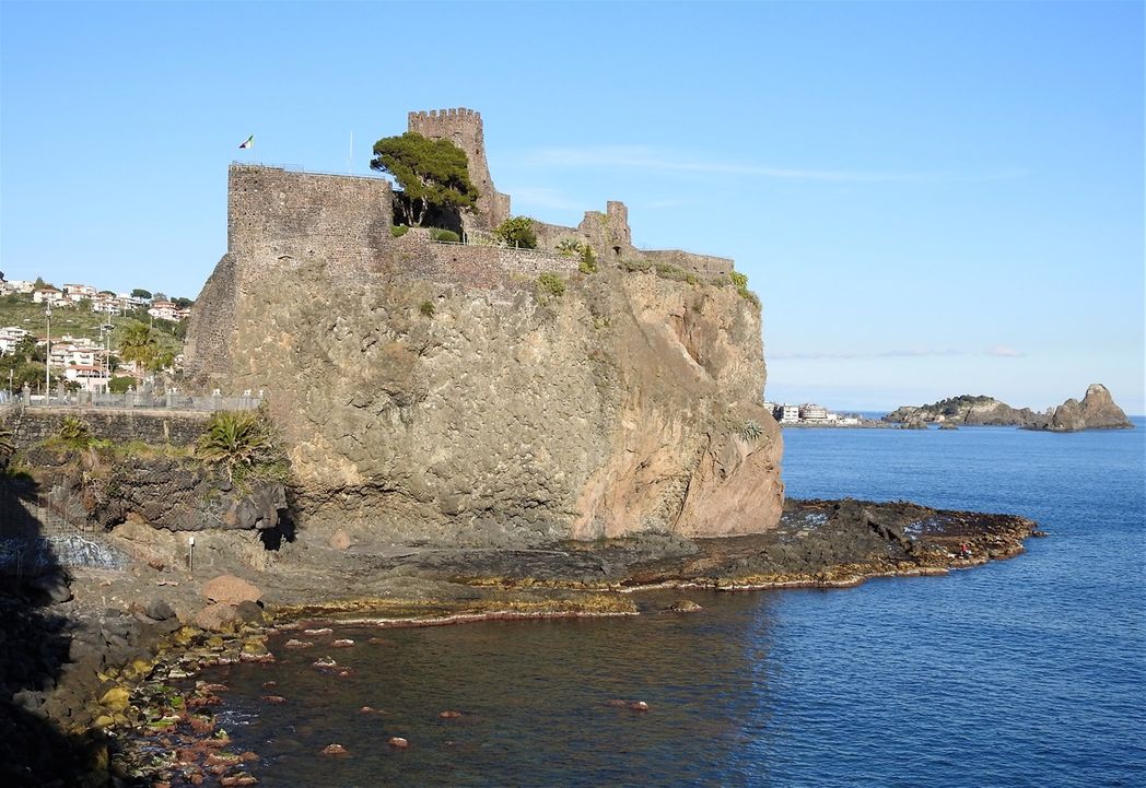 At the bottom of the castle rock there is a wide apron of volcanic rocks in beautiful colors.