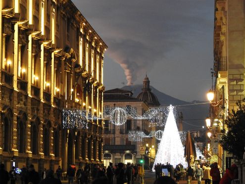 Via Etnea and Etna volcano smoking at the background.