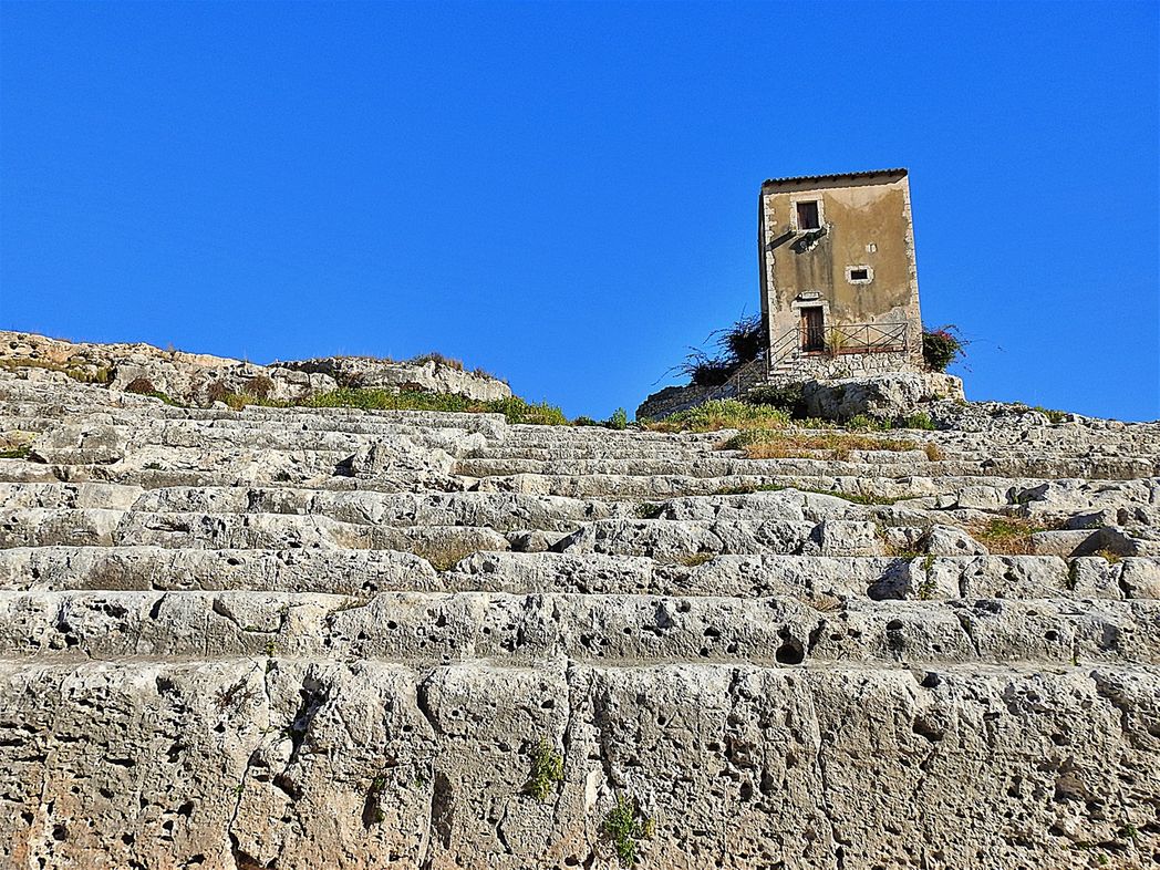 La casetta dei Mugnai. The cavea of Teatro Greco seen in the foreground.