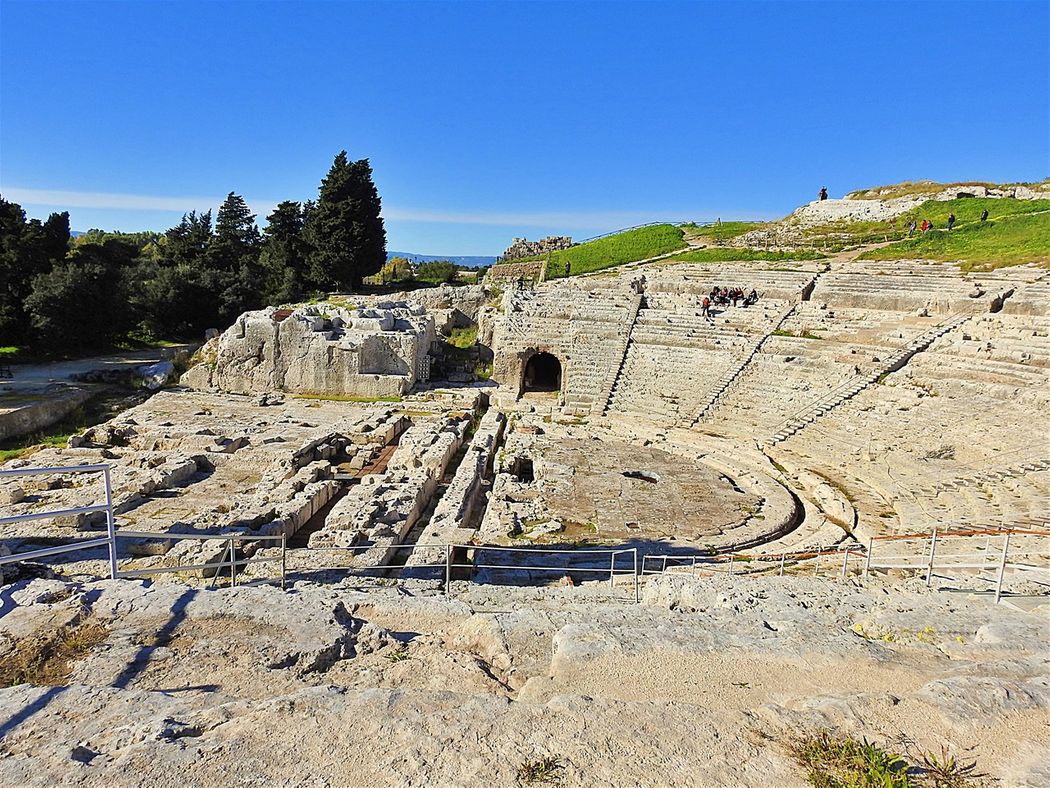 Greek Theatre (Teatro Greco) seen from the east. The scene building is entirely destroyed and only the cuttings in the bed rock for its foundations are now visible.