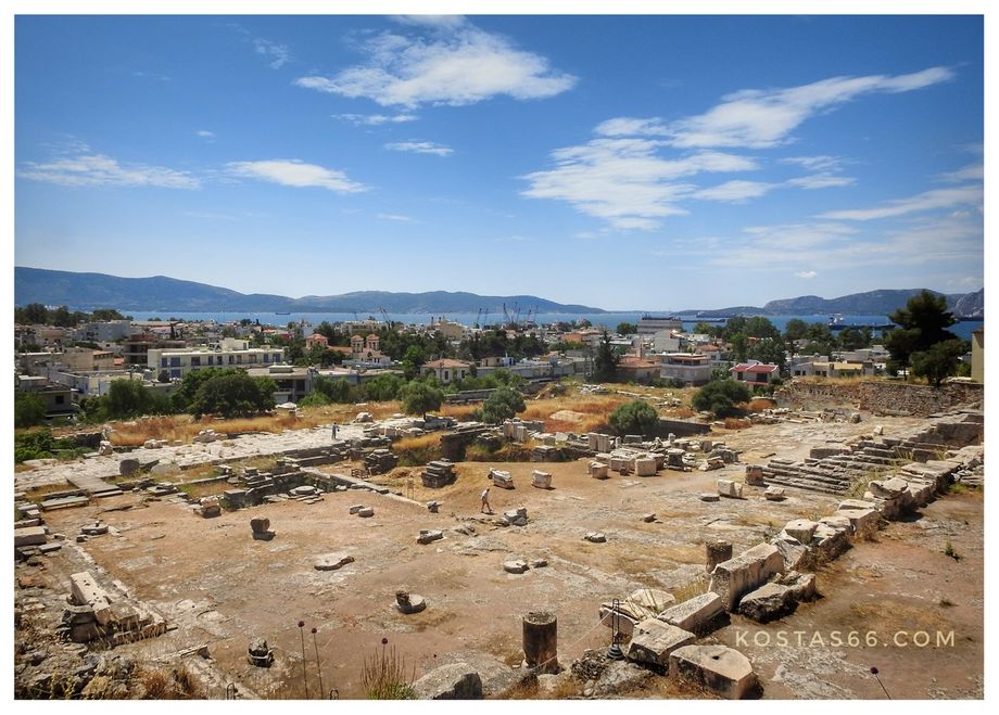 Overall view of the eastern part of the Telesterion from the Rock Terrace. The paved corridor seen on the left is the portico of Philo added later to the Telesterion. The modern city of Eleusis can be seen at the background.