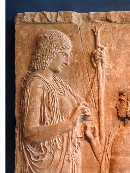 Demeter, the Kore (Persephone) and the King of Eleusis Triptolemos, who is preparing to teach agriculture to the world, according to the instructions of the goddess. This is  copy of the original exposed at the archaelogical museum of Athens.