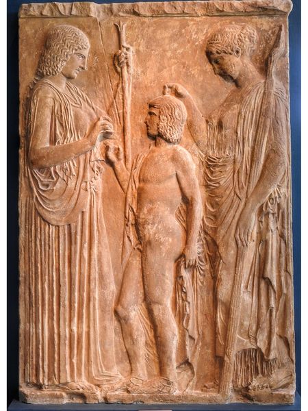 Demeter, the Kore (Persephone) and the King of Eleusis Triptolemos, who is preparing to teach agriculture to the world, according to the instructions of the goddess. This is  copy of the original exposed at the archaelogical museum of Athens.