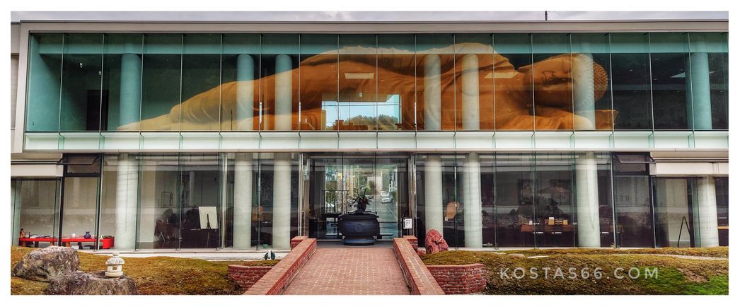 The reflection of the golden statue on the glass façade of the building standing just oppose it.