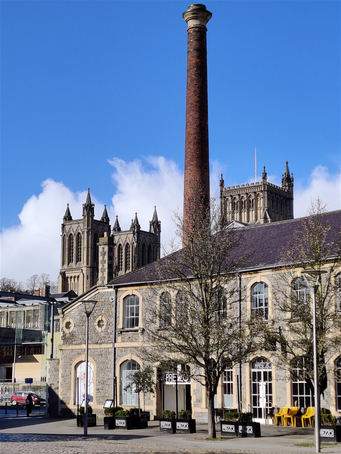 Bristol Cathedral behind a redeveloped old barbor building next to Millenium Square.