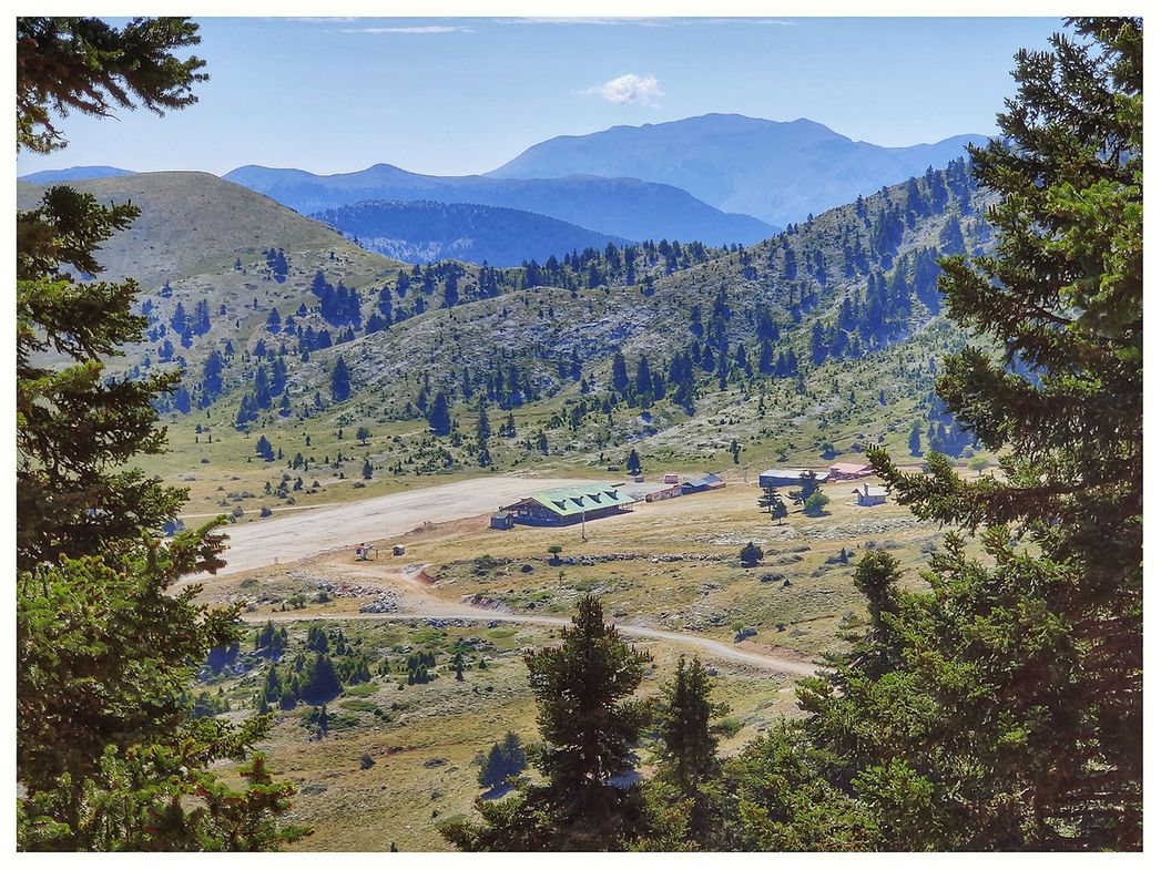 The ski resort main facilities and the parking lot seen from the road up to the refuge.