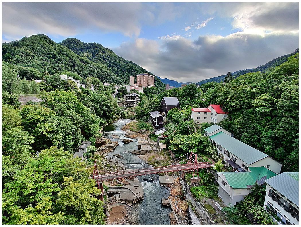 The view from Jozankeio Ohashi Bridge towards the town. The red bridge in the foreground is Koyama Bridge.