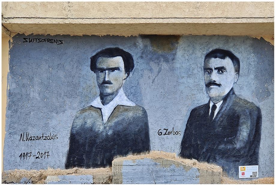 A wall painting of Kazantzakis and Zorbas at a sidewall of a house at Kalogria Beach.