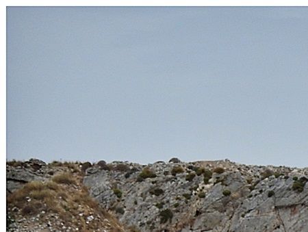 Cape Tigani. A series of cairns mark the easiest route across the pebbles and rocks up to the site.