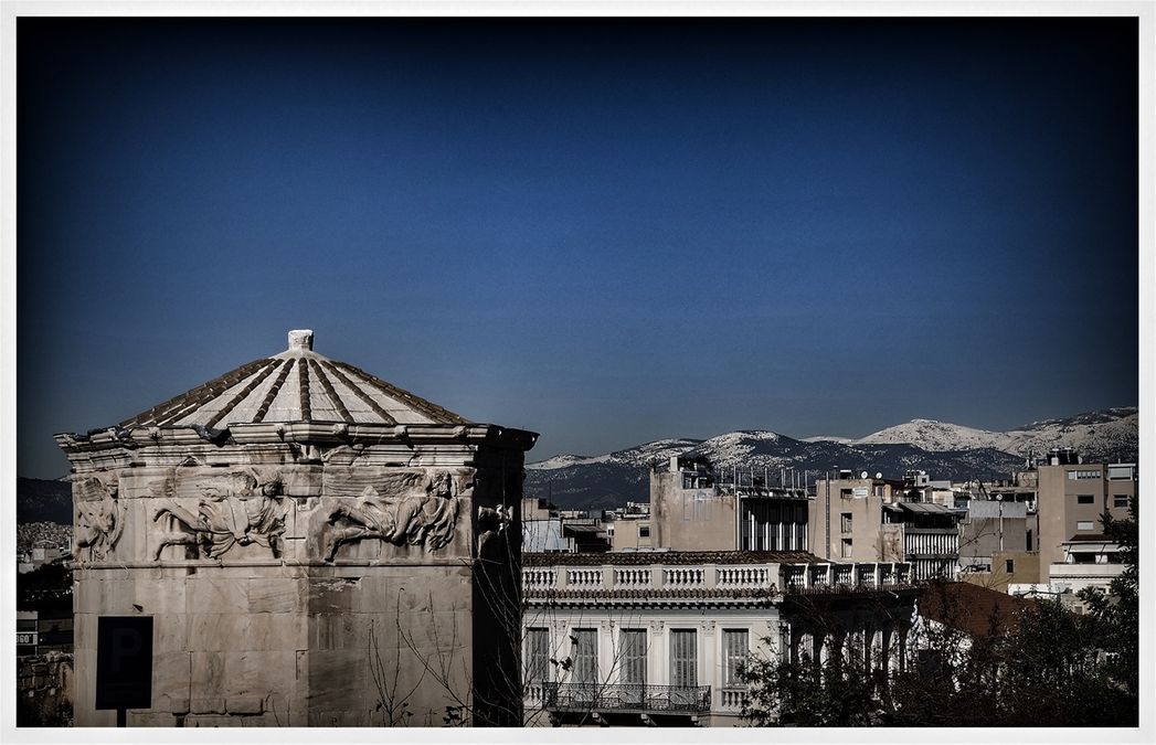 The tower of the Winds in a winter's evening. In the background, one can see the snowcapped Mount Parnitha.