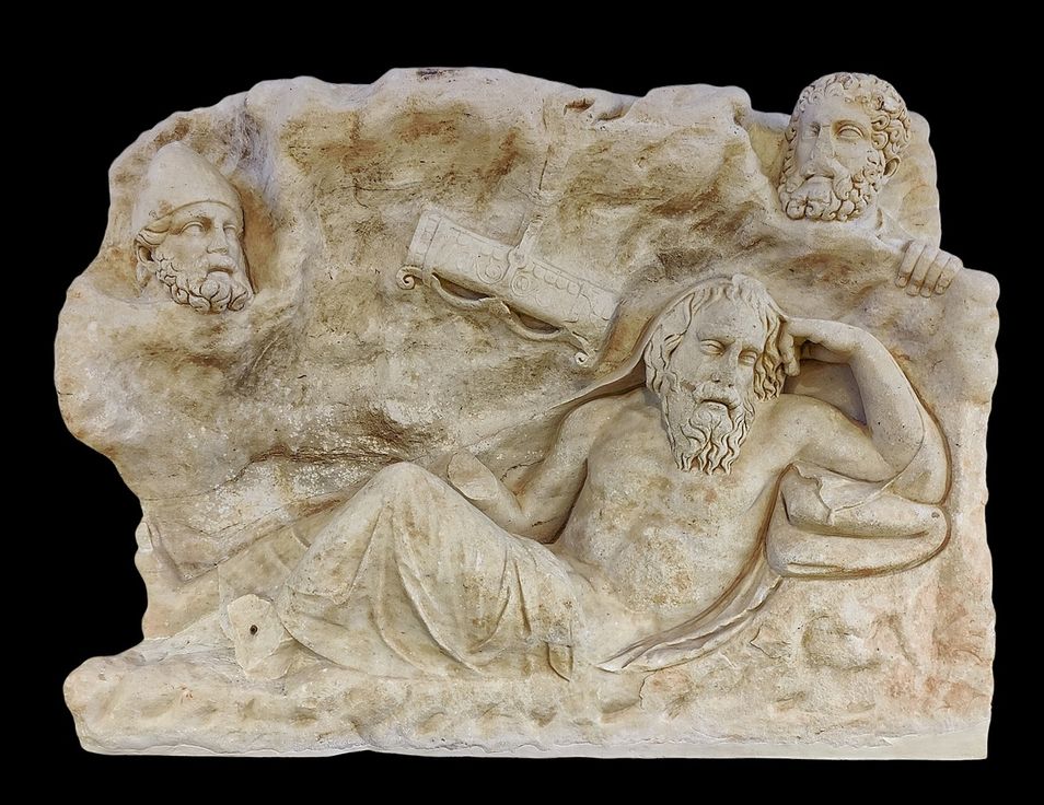 Marble slab found in Merenda. Before the middle of the 2nd century A.D.  The slab depicts the myth of the stealing of the weapons owned by the homeric hero Philoctetes, who had resorted to Lemnos, according to the version of the tragic poet Euripides.  Philoctetes, rather old and ill, is represented in a bent position into a cave. At the background, behind the cave's entrance, two male heads are visible. The first one, with a thick beard and a conical pilos is identified with Odysseus. The other one, probably Diomedes, with thick hair styled in locks and a beard dispossesses Philoctetes of his bow and quiver.