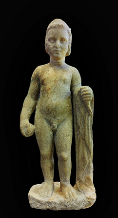 Marble statue of a nude boy. End of 4th century B.C.  His himation is over his bent left arm. He holds a bird and a ball.  He has a wreath on his hair.